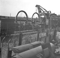 Castings, having been lifted over boundary fence, being loaded by railway personnel